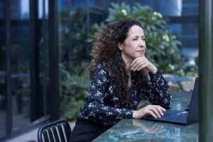 יועצת עסקית סיגל אמסלם במבט מהורהר מול המחשב.