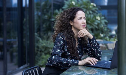 יועצת עסקית סיגל אמסלם במבט מהורהר מול המחשב.