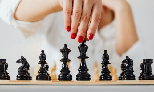 אסטרטגיה ומנהיגות עסקית - יד מבצעת מהלך הכרעה במשחק שחמט.